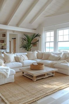 a living room filled with lots of white furniture and pillows on top of a rug