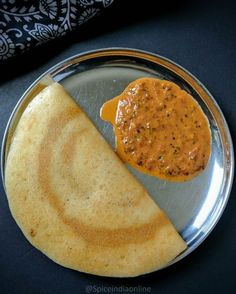 a plate with some food on it and a piece of bread in the middle next to it