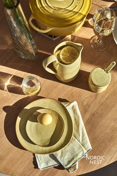 the table is set with yellow dishes and utensils, including one lemon slice