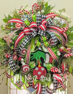 a christmas wreath hanging on the front door with candy canes and ornaments around it