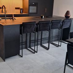 a kitchen with black chairs and an island