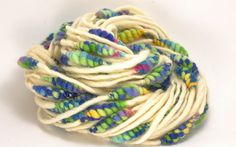 a ball of white yarn with multicolored beads on the top and bottom, sitting in front of a white background