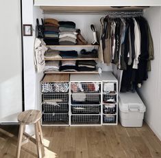 an organized closet with clothes, shoes and other items on shelves next to a stool