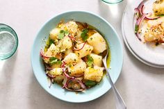 two bowls filled with food next to each other on a white tablecloth covered table