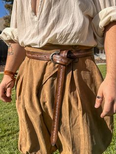 A belt perfect for any warrior. With an ornamental "Sleipnir" buckle and a bicolored tooled belt left long for the tied-off look. Made out of 7-8 oz veg tanned leather, meticulously hand carved and dyed. ONE SIZE FITS MOST (28"-51") Tooled Belt, Viking Belt, Medieval Belt, Viking Style, Tool Belt, Veg Tan Leather, Adult Costumes, Vikings, Hand Carved