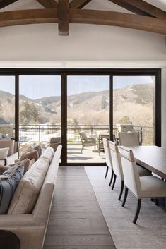 a living room filled with furniture and large windows