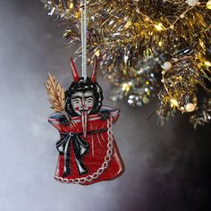 a red ornament hanging from a christmas tree