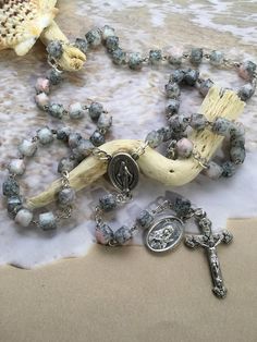 This saint Philomena rosary is made with glass beads. The beads are a beautiful marbled pink, white and black that have great detail. They are a square shape that give a fun and different texture. I use high quality stainless steel chain and wire. Each eye piece is handmade by me and overlapped as to keep it from breaking. This rosary should be sturdy and not come apart with proper everyday use.  It is the perfect gift for a confirmation, baptism or devotional. She is the patron saint of babies, Handmade Pink Rosary For Healing, Pink Healing Rosary With 8mm Beads, Pink Rosary, Mens Rosary, Saint Philomena, Protestant Prayer Beads, Chaplet Rosary, Mini Rosaries, Mens Face Mask