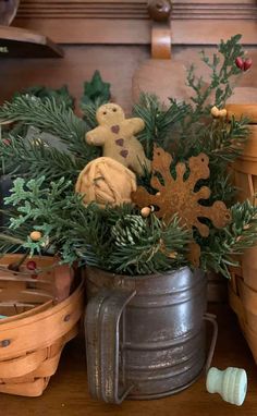 a metal bucket filled with christmas decorations on top of a wooden table next to other baskets