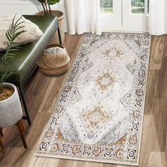 a large area rug with an ornate design on the floor in front of a window