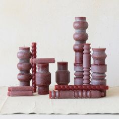 a group of red candles sitting on top of a white table next to each other