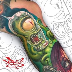 a man with a tattoo on his arm has a green monster in it's mouth