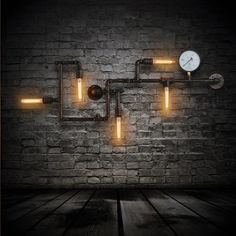 a brick wall with pipes and a clock on it, lit up by yellow lights