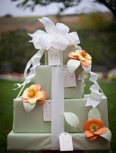 a three tiered wedding cake with flowers on the top and price tags attached to it