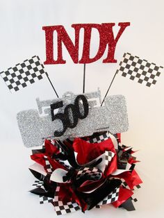 a red and black bow with the word indy on it, surrounded by race flags