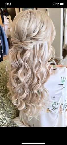 the back of a woman's head with wavy blonde hair and curls in it