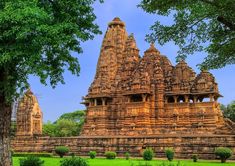 an elaborately carved building in the middle of a park