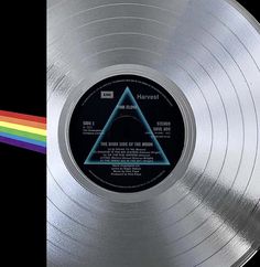 the dark side of the moon on a silver colored vinyl record with rainbow in the background