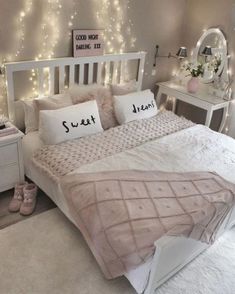 a bedroom with white furniture and fairy lights on the wall above the bed is decorated in neutral colors