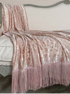 a bed with a pink blanket on top of it