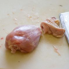 a piece of raw meat on a cutting board next to a knife