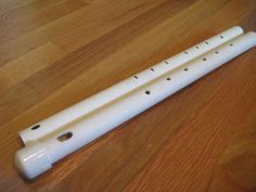 a white flute laying on top of a wooden floor