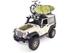 a white jeep with a bike on the top and a green kayak strapped to it's roof