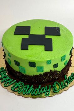 a green cake with black letters on it