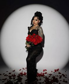 a woman in black dress holding red roses