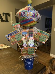 a birthday cake made out of magazines on top of a table with a dog laying next to it