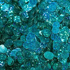 many blue and green sequins are scattered together