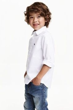 a young boy wearing jeans and a white shirt