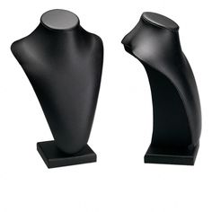 two black vases sitting next to each other on top of wooden bases, one is shaped like a woman's torso