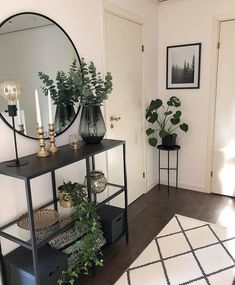 a room with a mirror, plant and other items on the shelf in front of it