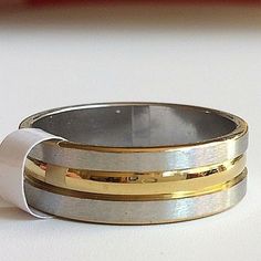 two gold and silver wedding bands on top of each other