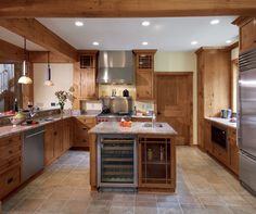 a large kitchen with wooden cabinets and stainless steel appliances, including a wine cooler in the center