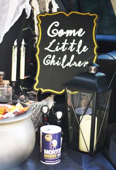 a sign that says come little shilbber next to some candles and other items