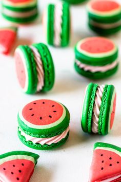 watermelon sandwich cookies with green frosting and white icing are arranged on a table