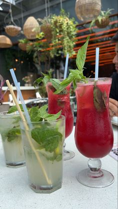 three glasses filled with different types of drinks