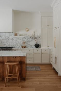 a kitchen with marble counter tops and wooden stools