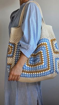 a woman is holding a crocheted purse