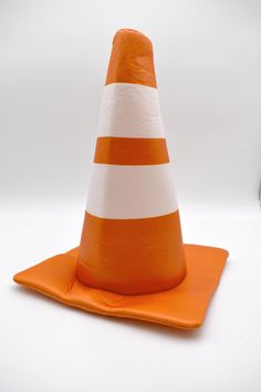 an orange and white traffic cone sitting on top of a napkin