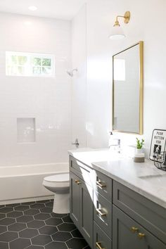 a bathroom with white walls and gray cabinets