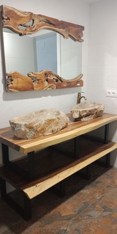 a bathroom with two sinks and a large mirror on the wall above it, along with a bench made out of wooden planks