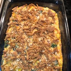 a casserole dish with meat and vegetables in it on a baking sheet, ready to be eaten