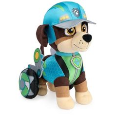 a small stuffed dog wearing a blue hat and green shirt with a paw patrol badge on it's chest