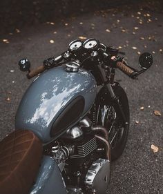 a close up of a motorcycle parked on the side of the road with trees in the background