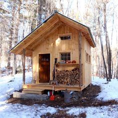 a small cabin in the woods with snow on the ground