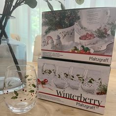 two empty wine glasses sitting on top of a table next to a vase filled with flowers