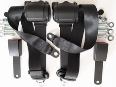 two black straps are attached to the back of a pair of seatbelts with metal hardware